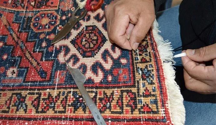 Person repairing rug with equipment