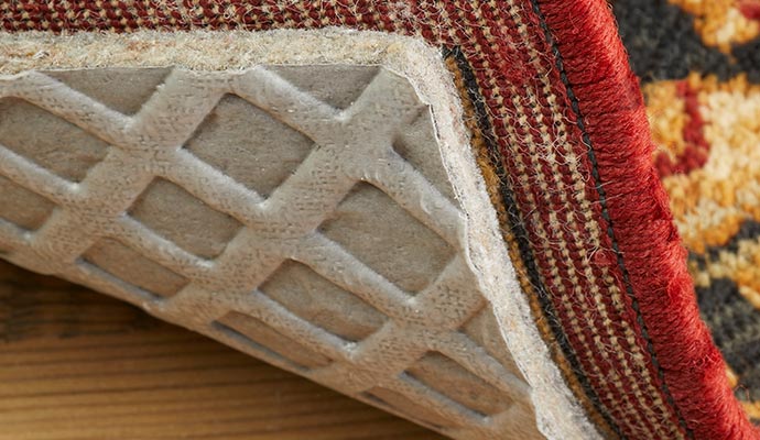 Close-up of a non-slip rug pad underneath a patterned area rug
