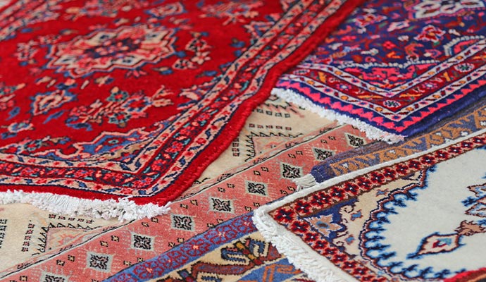 Overlapping oriental rugs in red, navy, cream, and salmon patterns