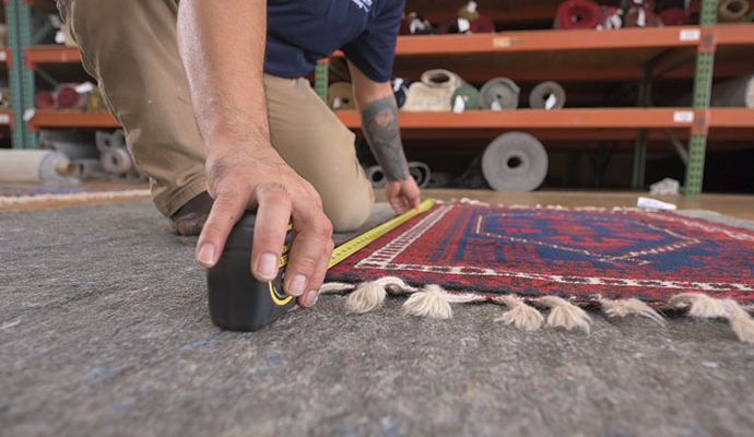 person taking accurate measurements of rug for custom resizing