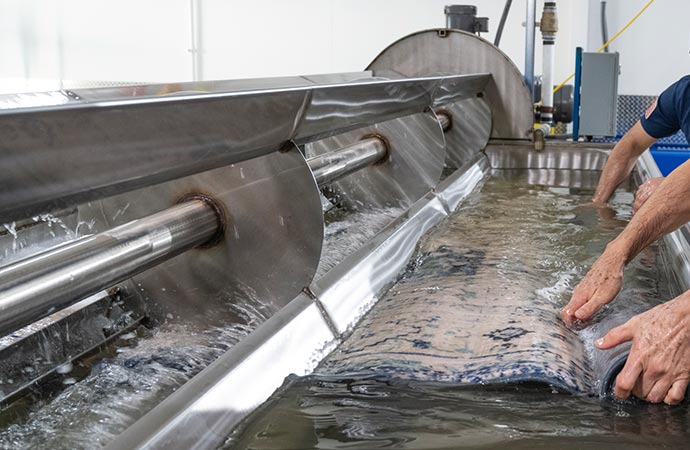 Professional worker washing rug by machine