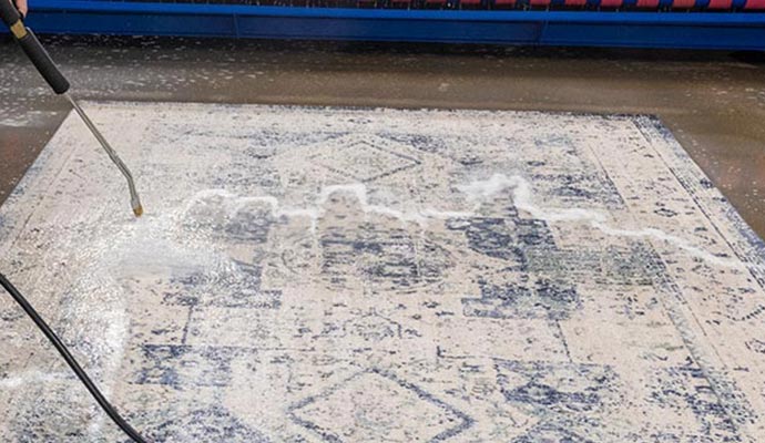 Pressure washing patterned rug with cleaning foam