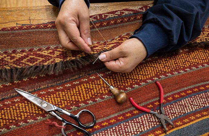 Professional worker repairing rug