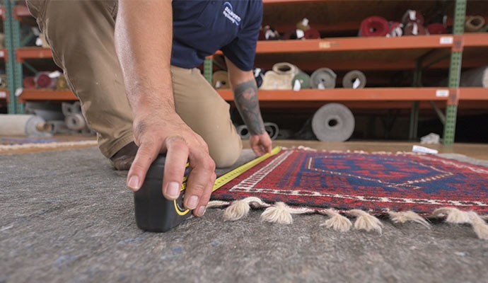 Professional taking measurement of a rug