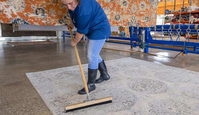 A person is cleaning rug using hot water extraction method