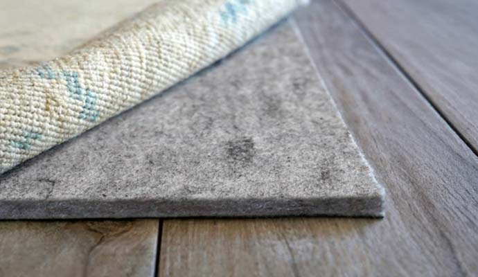 Felt rug pad under area rug on hardwood floor