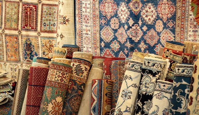 Multiple rolled rugs neatly stored in a storage area