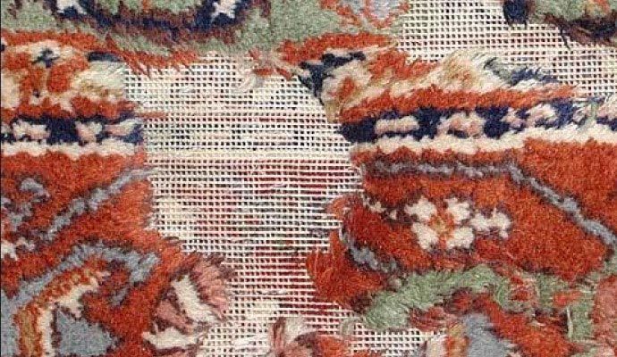 Rug with holes and damage caused by moths