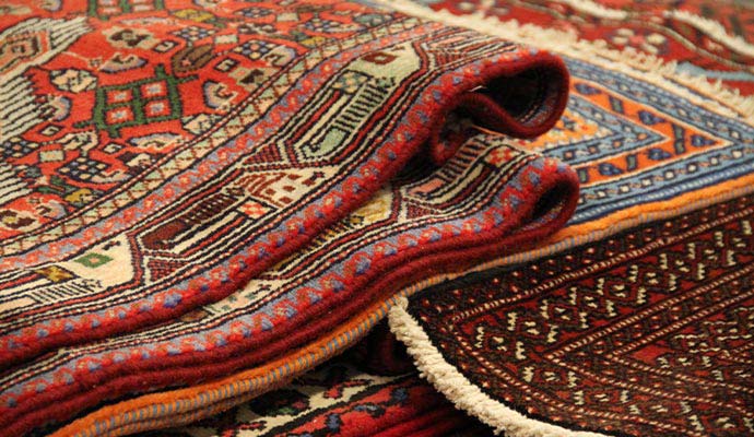 Stack of folded colorful Oriental rugs