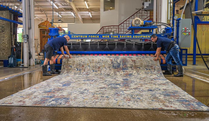 Technicians cleaning rug with Centrum Force machine